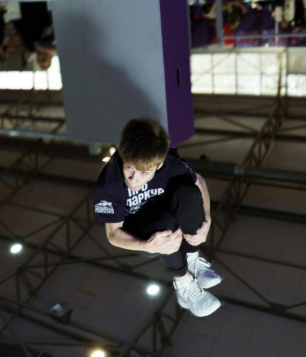 Man performing a controlled strength exercise in a minimalist gym.